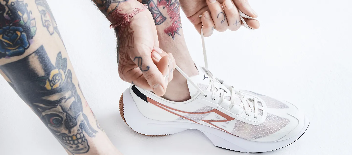 A person laces up their Diadora Equipe Corsa running shoes. 