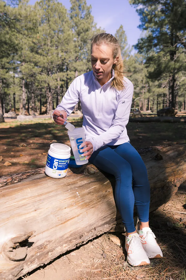 Emily Sisson carefully dumps some UCAN Powder into her water bottle.