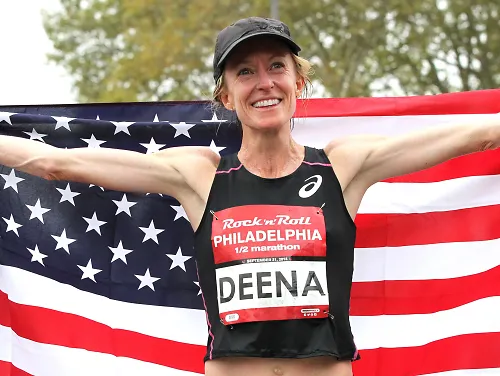 Elite runner Deena Kastor poses with an American flag after a race