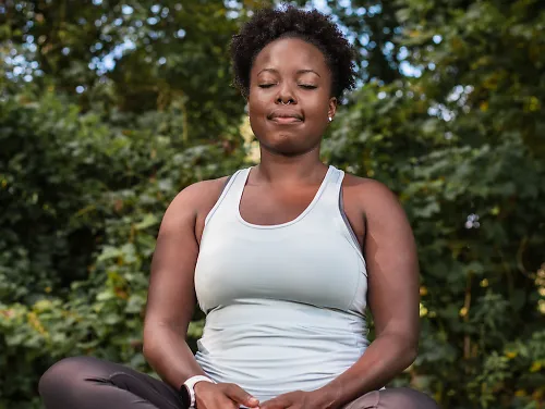 A woman meditates in a park