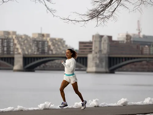 Erika Kemp runs along a snowy river.