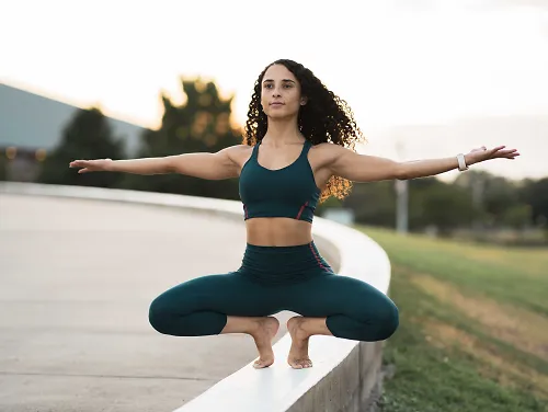 Francheska in a low squat balanced on a wall