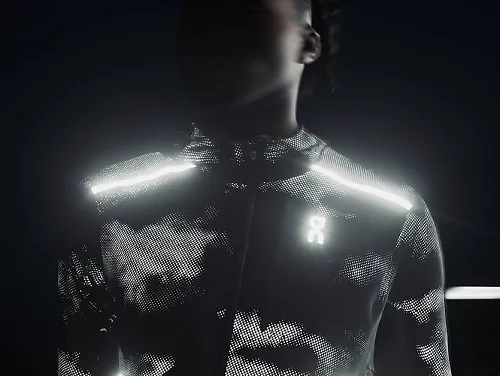 A runner wearing the On Lumos Weather Jacket in the dark.