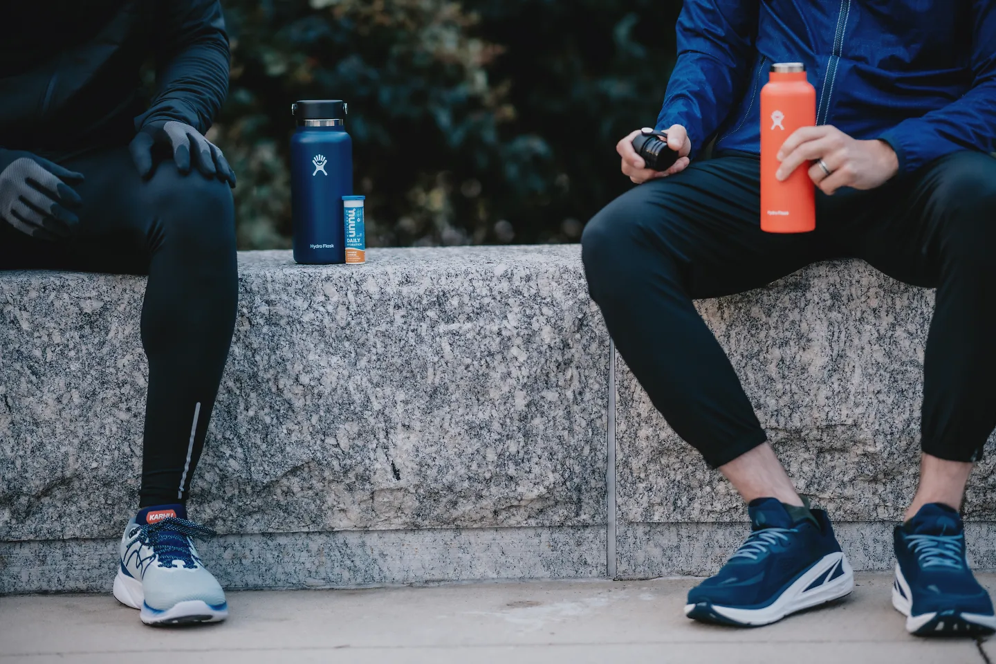 Two runners sit while mixing an electrolyte mix.
