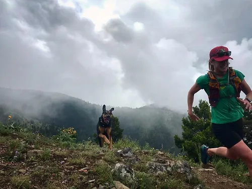 Woman running in the mountains with her dog