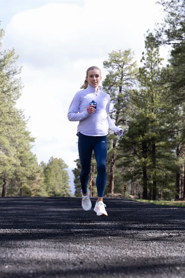Emily Sisson runs while downing a UCAN gel.
