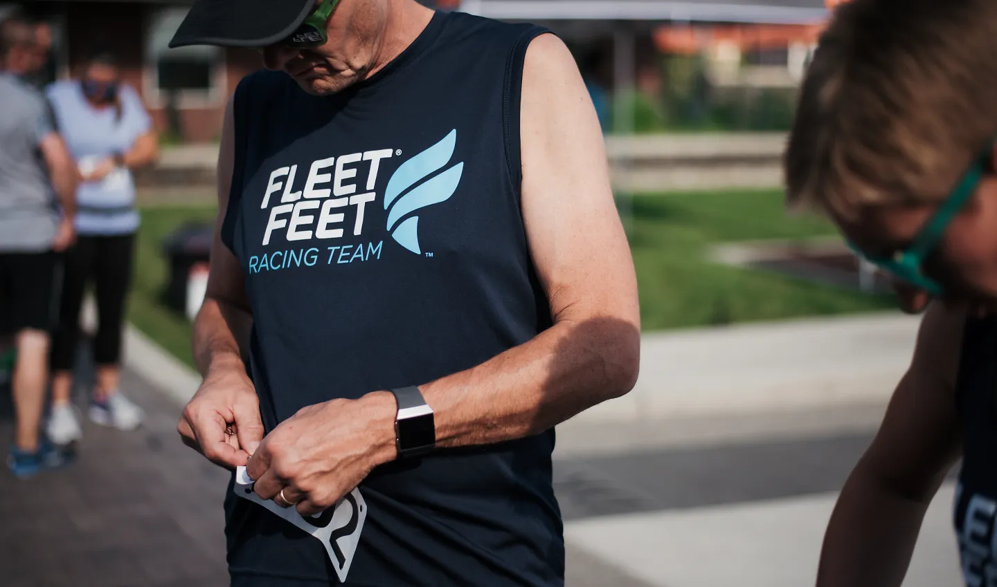 A man pins on his bib at a 5K race