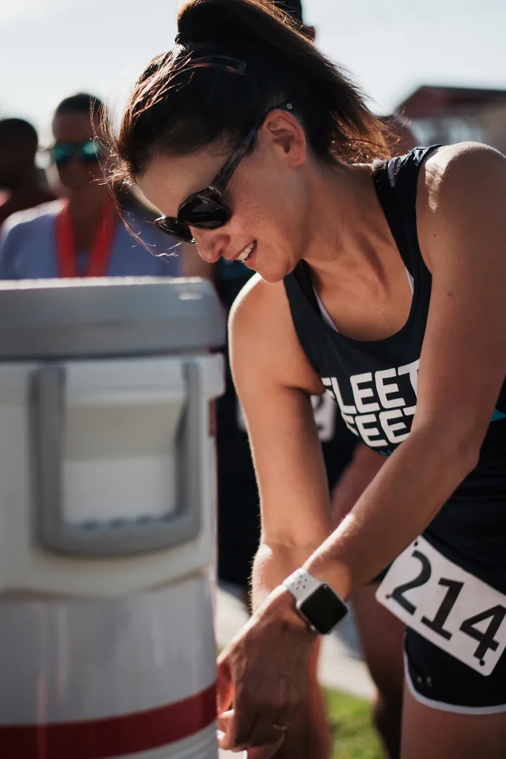 A woman fills her cup with a recovery drink