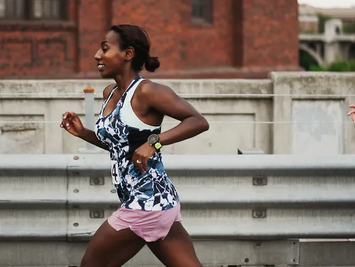 Two women run in a race, both smiling as they go