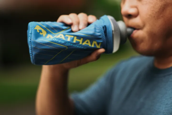 A runner takes a sip from a Nathan drink bottle