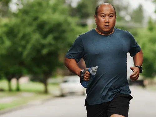 A man runs alone down a neighborhood street