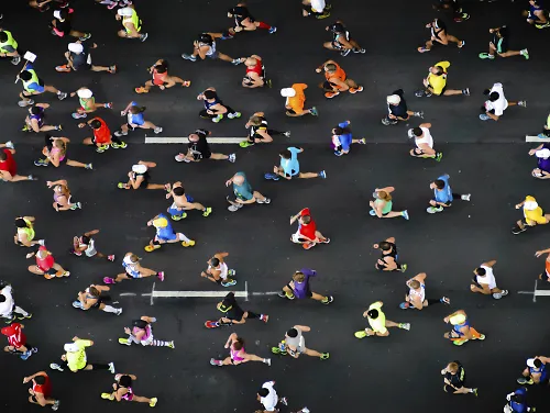 A group of people run a race on a street
