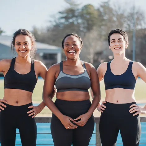 Three women wearing sports bras
