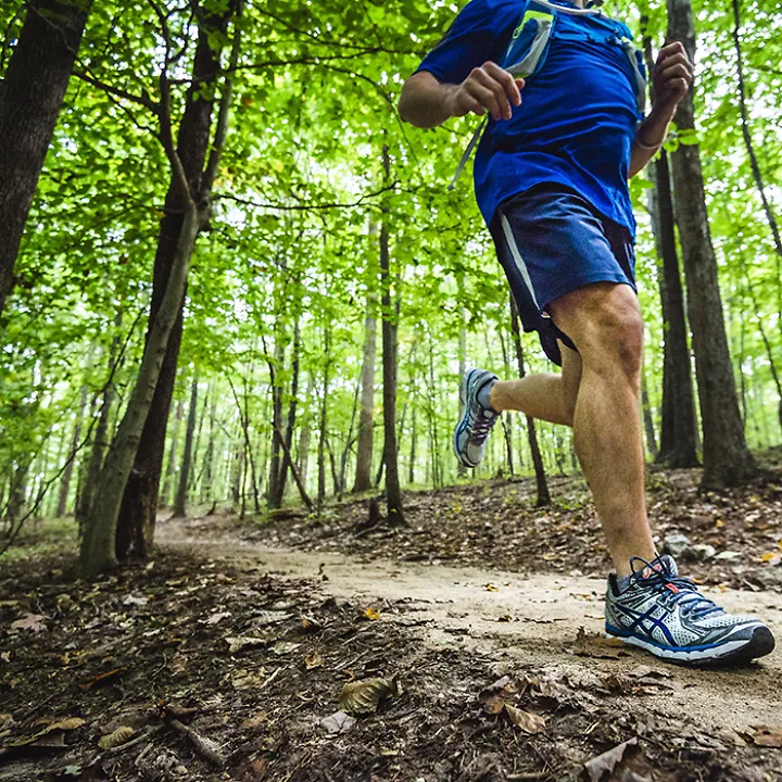A runner on a trail run through the woods