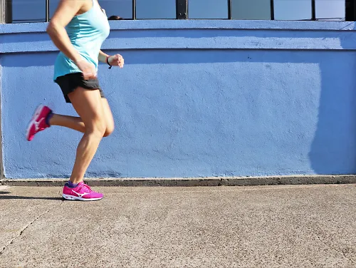 A woman running in Mizuno's ProjectZero edition of the Waveknit R2 running shoe