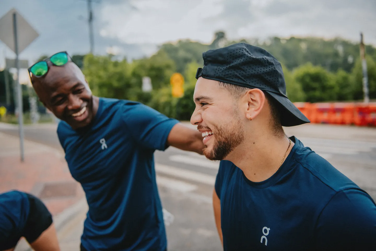 Two men laugh with each other after a run. 