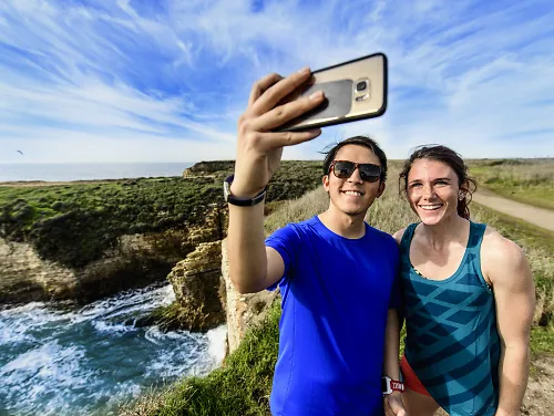 Two runners taking a selfie with a smartphone during a run