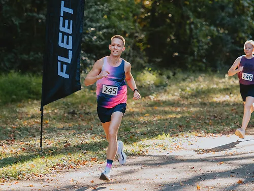 runner in race with fleet feet flags in the background