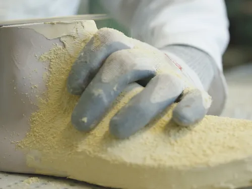 A shoe designer shaves a last to create a new running shoe