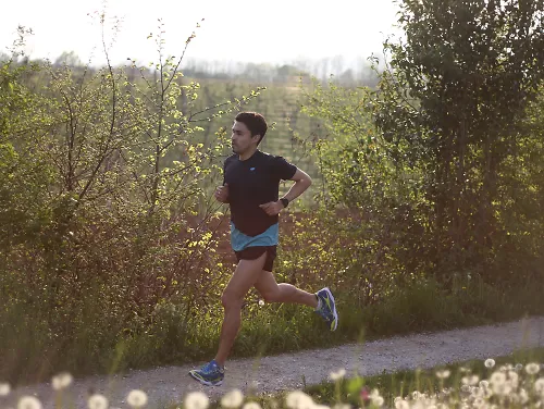 man running on gravel path at sunset