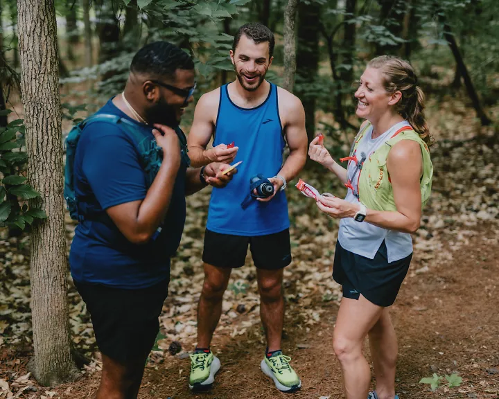 Three individuals with different body shapes talking after a trail run