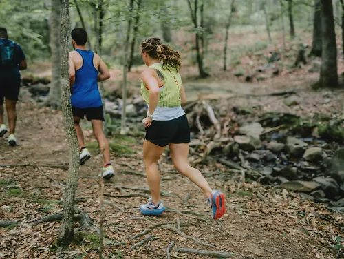 Two male and one female run on the trails 