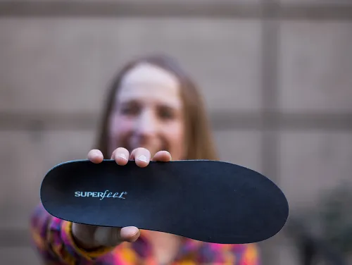 A woman holds a Superfeet insole