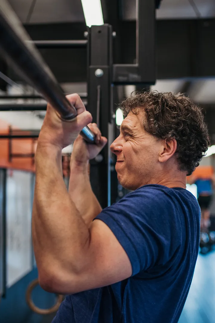 A man doing pull ups in a gym
