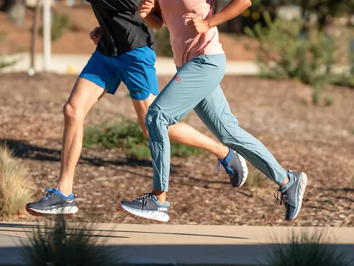 A man and woman running the the HOKA Gaviota 3 shoes
