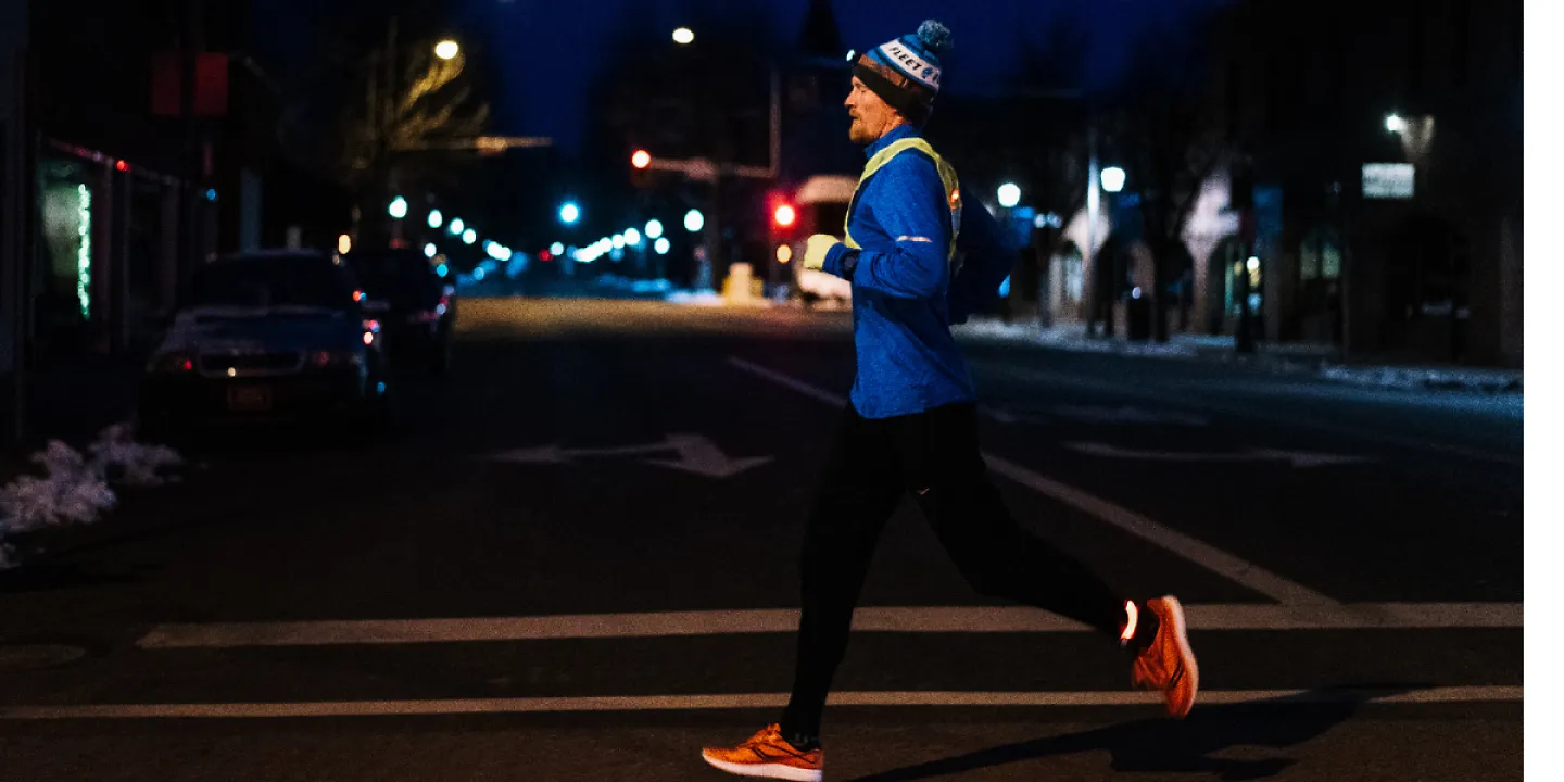 Man running in the dark with a headlamp and reflective vest