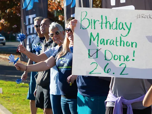 Friends and family mark the finish line of Jen Neary's person marathon