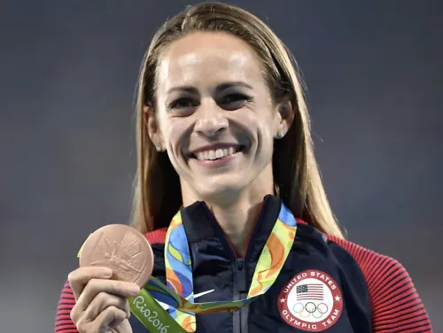 Jenny Simpson smiles and holds up her Olympic Bronze medal