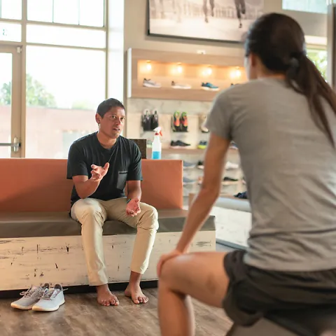 A Fleet Feet employee helping a customer