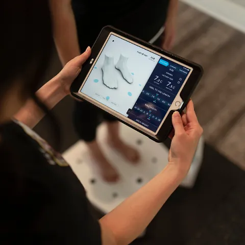 Outfitter Holding A Customer Foot Scan