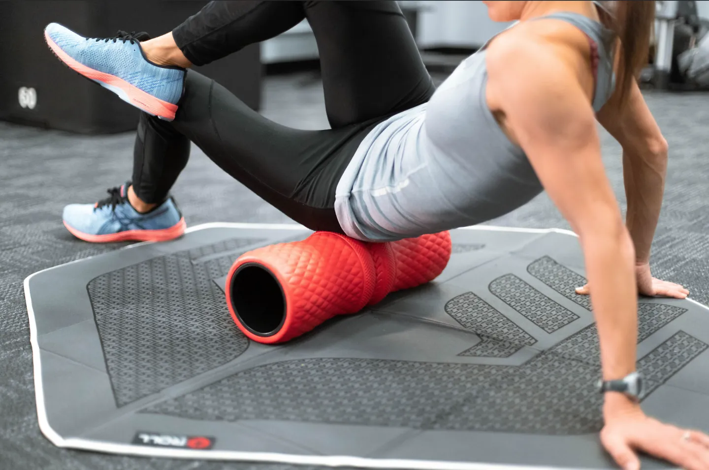 A woman using the ROLL Recovery R4 foam roller