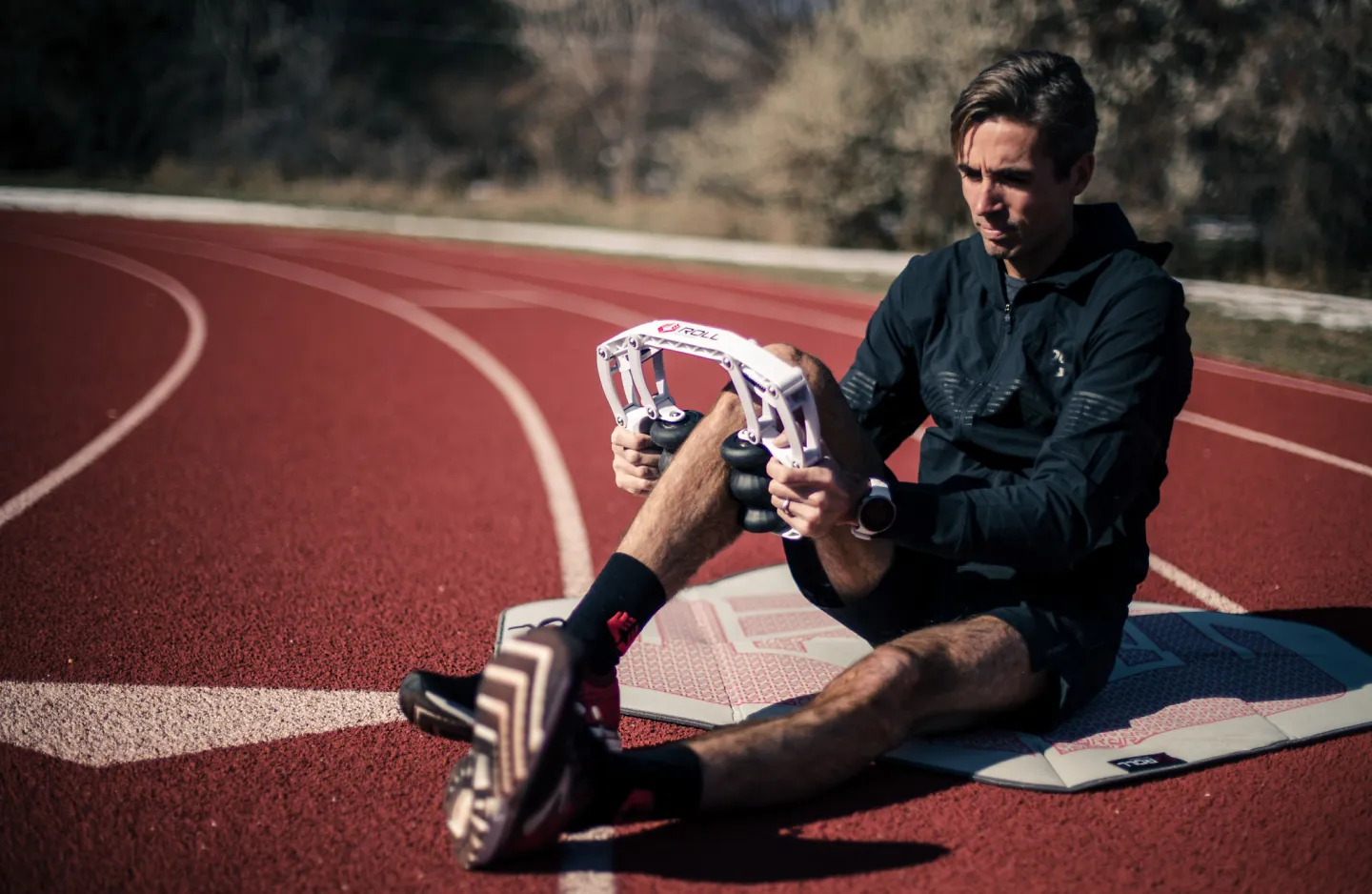 A man massages his leg with the Roll Recovery R8 massager