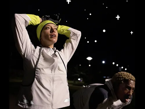 A runner wearing the Brooks Run Visible convertible jacket catches her breath. 