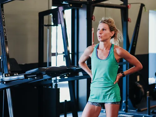 A runner rests between sets while doing strength training in a gym