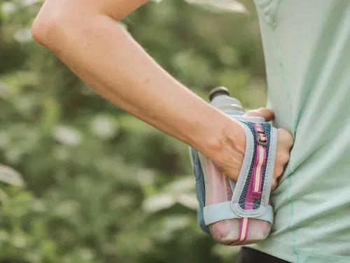 A runner keeps a handheld water bottle to stay hydrated during a summer workout